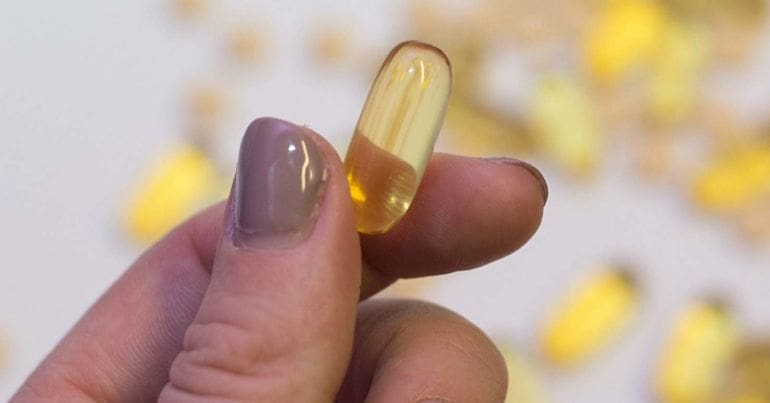 Capsule held between fingers