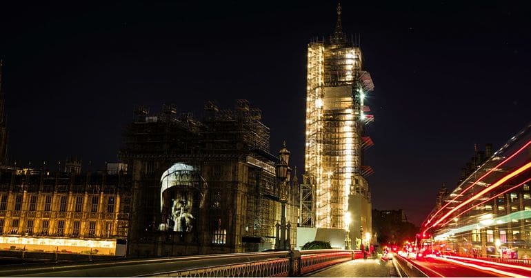Riot police officer demanding silence projected onto Houses of Parliament via Westminster Bridge