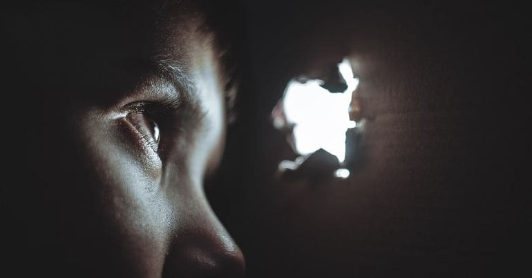 Child watching through hole