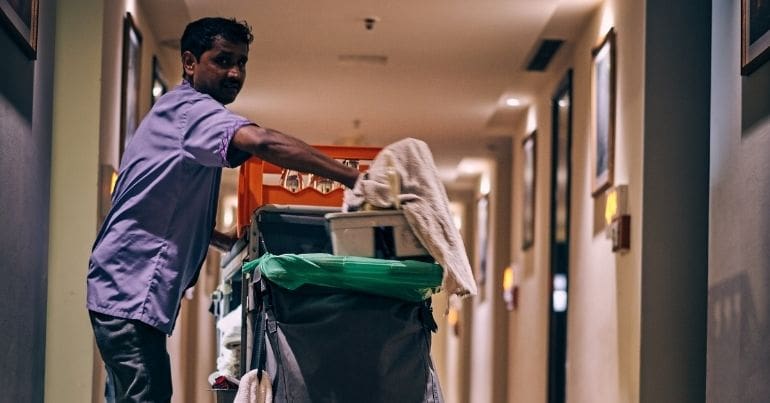 A cleaner in a hotel hallway with his equipment TUC Covid Inquiry