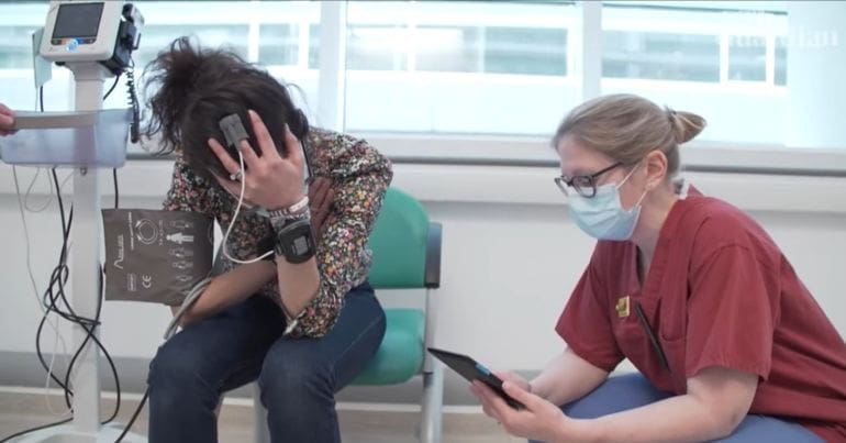 Patient with head in hand speaking to a medical professional