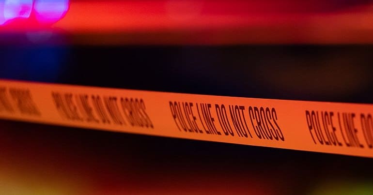 A line of police tape at a shooting in Minneapolis, Minnesota, at night.
