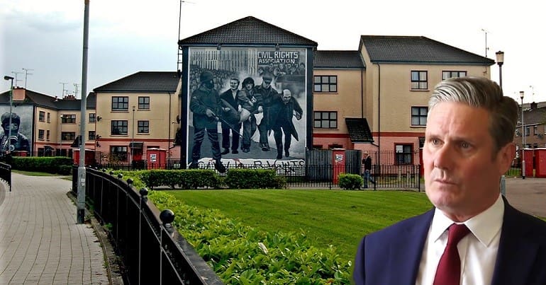A picture of the Bloody Sunday mural in Derry with Keir Starmer looking at it