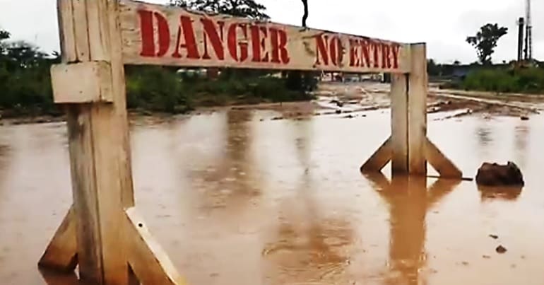A sign that read "Danger No Entry" in a muddy pool of water near oil exploration site in Namibia