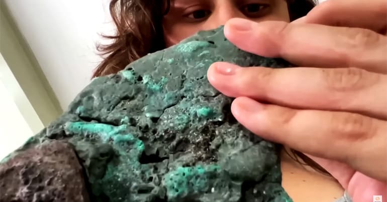 Geologist Fernanda Avelar Santos looks at a plastic rock made up in part from pollution. She found the rocks on Trinidade island.
