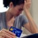 A woman holding a credit card TUC debt