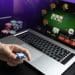 online casino man holding poker chip in front of laptop free