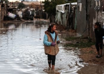 Gaza climate crisis a girl standing in flood water