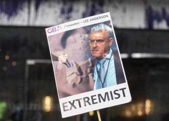 GB News a placard with a picture of Lee Anderson that says extremist