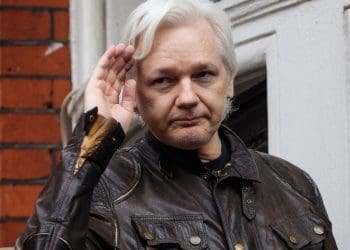 Julian Assange saluting outside extradition