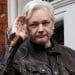Julian Assange saluting outside extradition