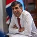 Rishi Sunak laughing at a desk with a Union Jack flag behind him DWP benefit fraud Private Eye