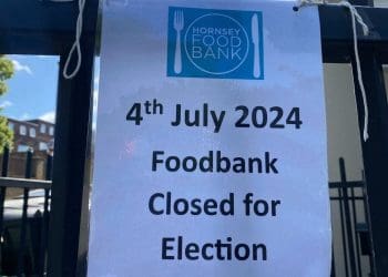 Sign attached to railings outside a church, which reads: Hornsey Food Bank - 4th July 2024 foodbank closed for election.