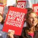 a protester holding a sign saying "disabled people say no to assisted suicide" assisted dying