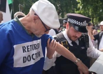 Police arresting a retired doctor at a Lift the Ban protest Defend Our Juries