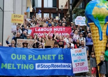 Protesters holding signs which read 'our planet is melting' and 'Labour must stop Rosebank' fossil fuels