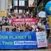 Protesters holding signs which read 'our planet is melting' and 'Labour must stop Rosebank' fossil fuels
