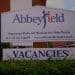 Abbeyfield Chester sign outside residences, reading: "Supported Sheltered Housing for Older People" with the telephone number and website for Abbeyfield Chester, and "VACANCIES" beneath.