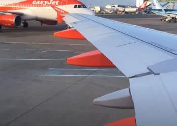 Gatwick runway. Wing of plane from aircraft window with an EasyJet plane in the background.