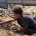 A young Palestinian boy Israel has displaced in Gaza sits amid landfill.