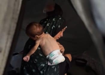 Palestinian mother holds her malnourished baby in a tent in Gaza IRC children