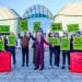 A figure wearing a large Rachel Reeves head stood between two oversized red Budget briefcase boxes, one labelled “billionaire budget”, the other “people’s budget”, surrounded by campaigners holding banners and placards reading “Tax the super-rich”, “Tax wealth now” and “Reeves: Pick a side” Labour conference