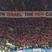 Football fans in a stadium hold an enormous banner which reads: "Show Israel the red card" Israel FIFA UEFA ban