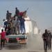 Group of armed Palestinian men aboard the back of a vehicle, as masked men holding guns walk away from it to its rear Israel gangs Gaza