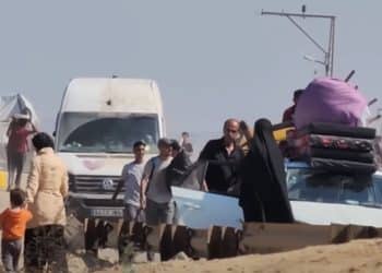 Displaced Palestinians in Gaza carry their possessions by hand or piled on vehicles, seeking safety and shelter.